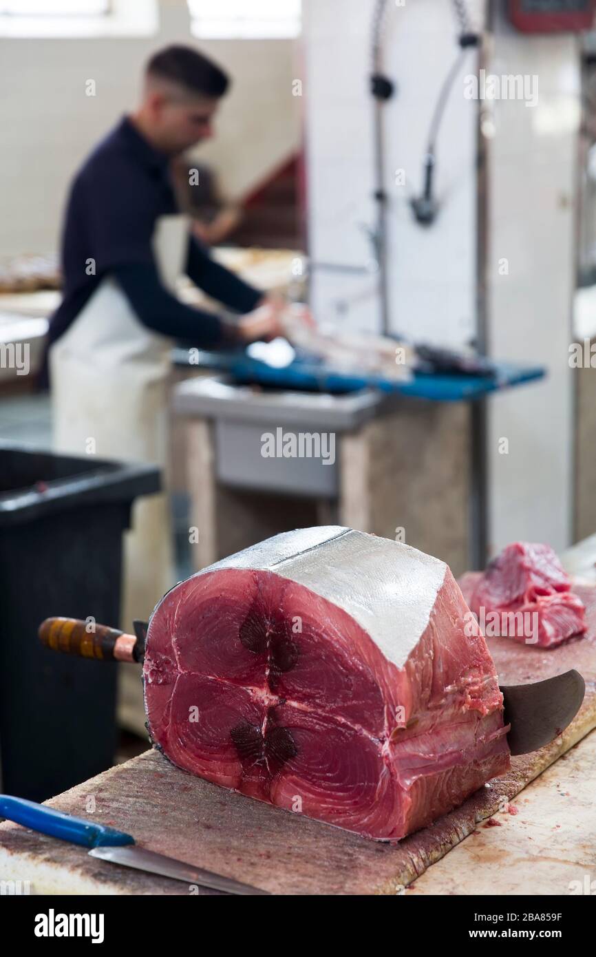 FUNCHAL, PORTUGAL - 15 FÉVRIER 2020: Un homme non identifié qui coupe le thon Mercado dos Lavradores (marché agricole) à Funchal sur l'île de Madère, au Portugal. M Banque D'Images