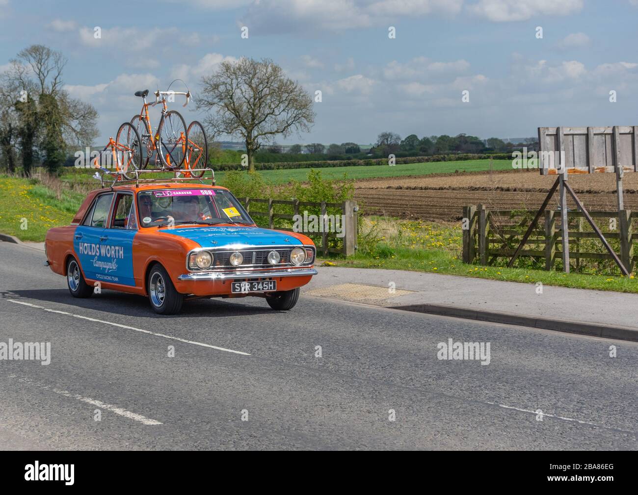 Pocklington, East Yorkshire, Royaume-Uni, 05/03/2018 - une voiture d'équipe de course à vélo Ford Cortina bleu et orange au Tour de Yorkshire. Banque D'Images