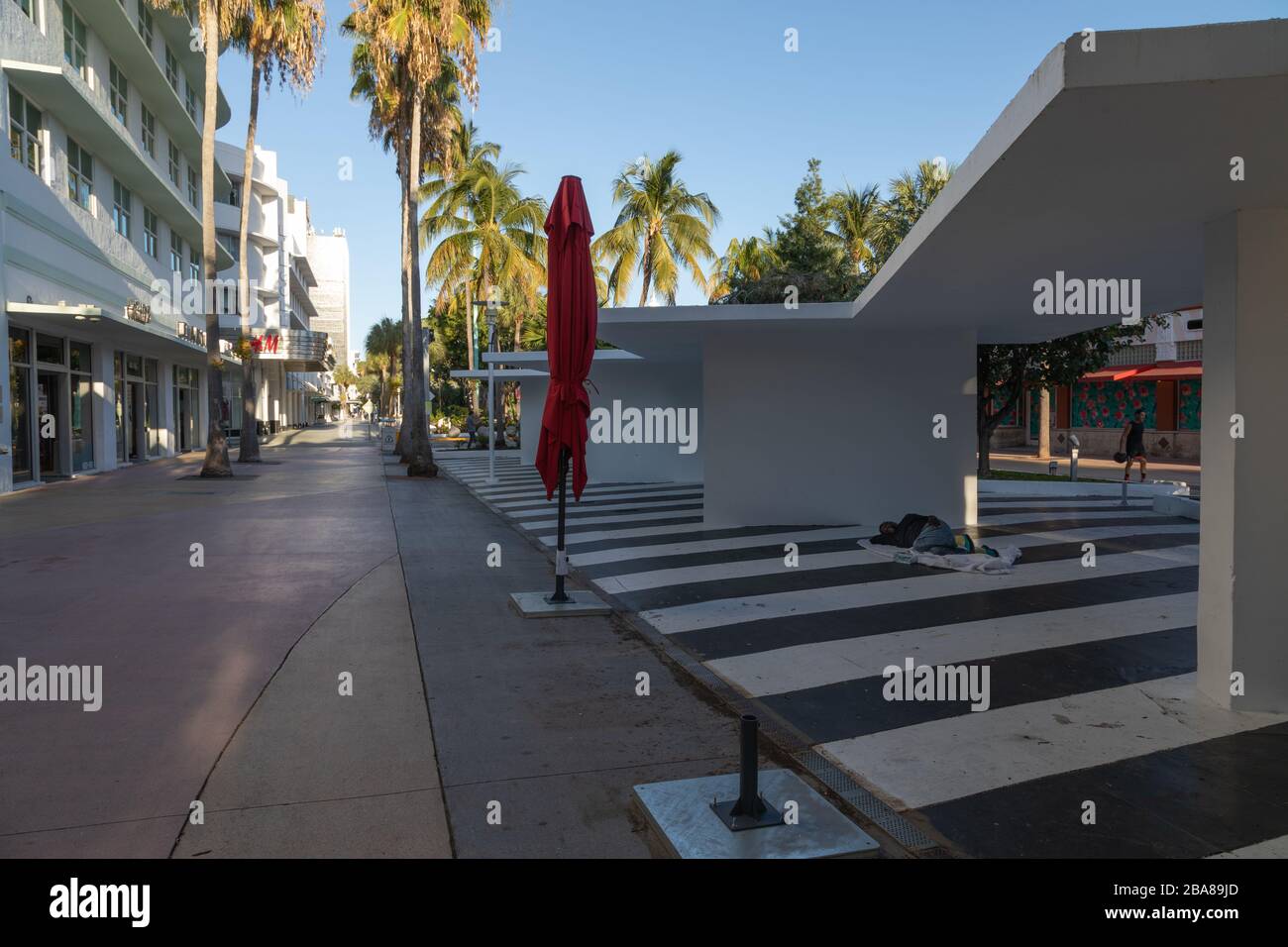 Miami Beach, Floride, États-Unis - 2020/03/23: Pratiquement vide Lincoln Road après la fermeture des affaires, des restaurants et des plages. Les sans-abri dort sur le plancher où Banque D'Images