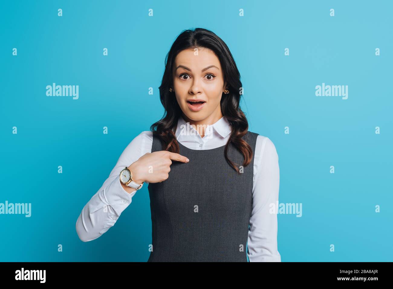 une femme d'affaires choquée qui se montre avec le doigt tout en regardant  l'appareil photo en bleu Photo Stock - Alamy