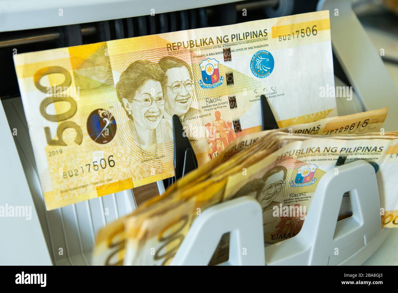 Vue rapprochée d'une trésorerie de 500 peso philippins sortant de la machine du comptoir-caisse Banque D'Images