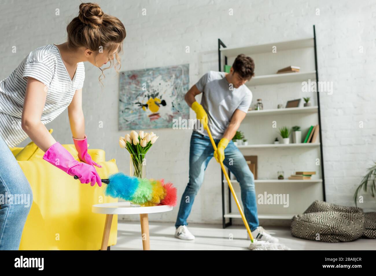 foyer sélectif de l'homme et de la femme faisant le nettoyage de printemps dans l'appartement Banque D'Images