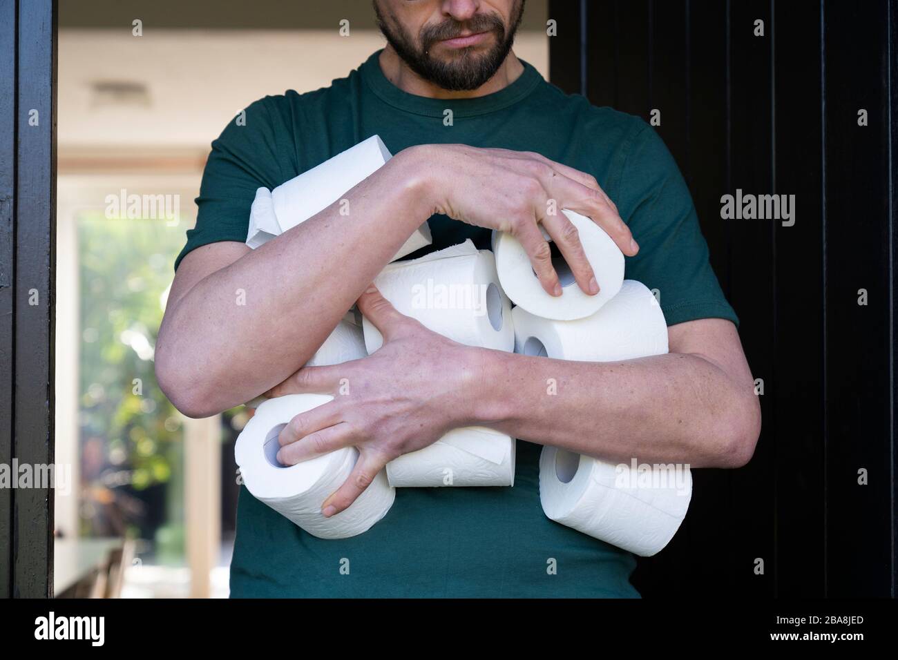 L'homme hodant le rouleau de toilettes pendant l'achat de panique pandémique de Coronavirus. Banque D'Images