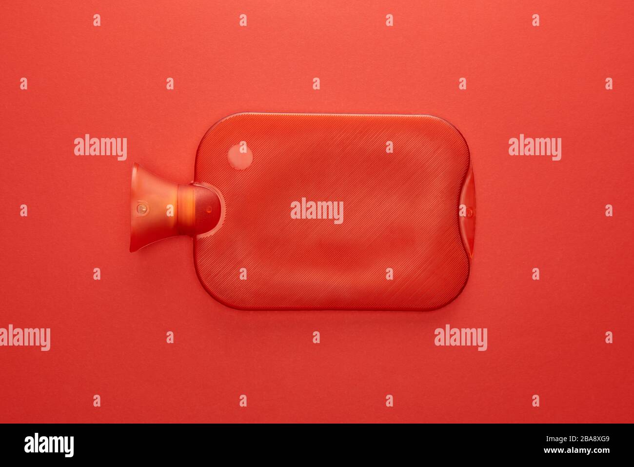 Vue de dessus de la bouteille d'eau chaude isolée sur le rouge Banque D'Images