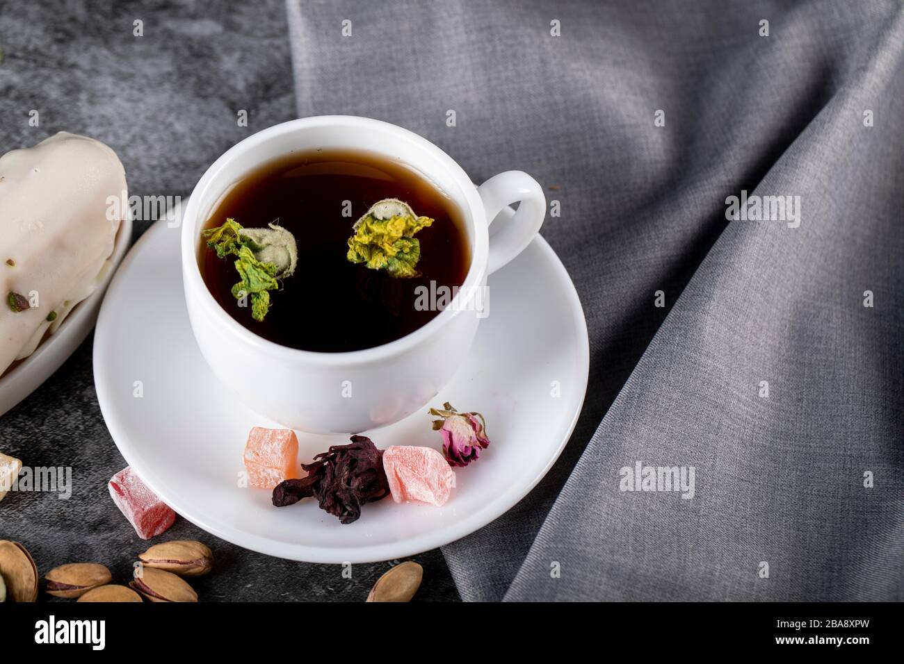 Une tasse de thé aux noix, au lokum turc et aux fleurs Banque D'Images