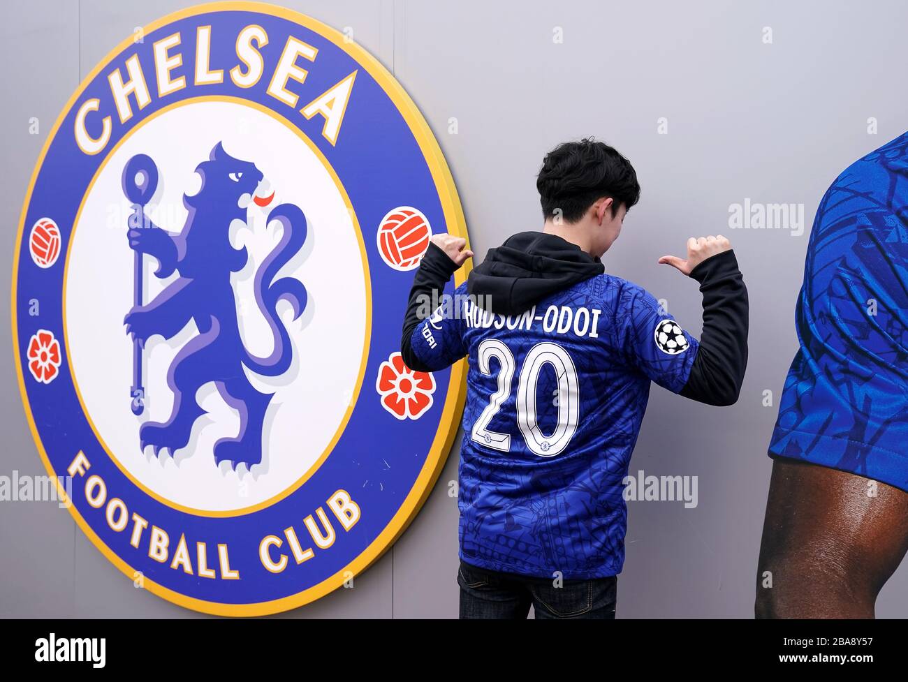 Un jeune fan pose devant l'écusson du club de football de Chelsea avec un maillot Callum Hudson-Odoi avant le match Banque D'Images