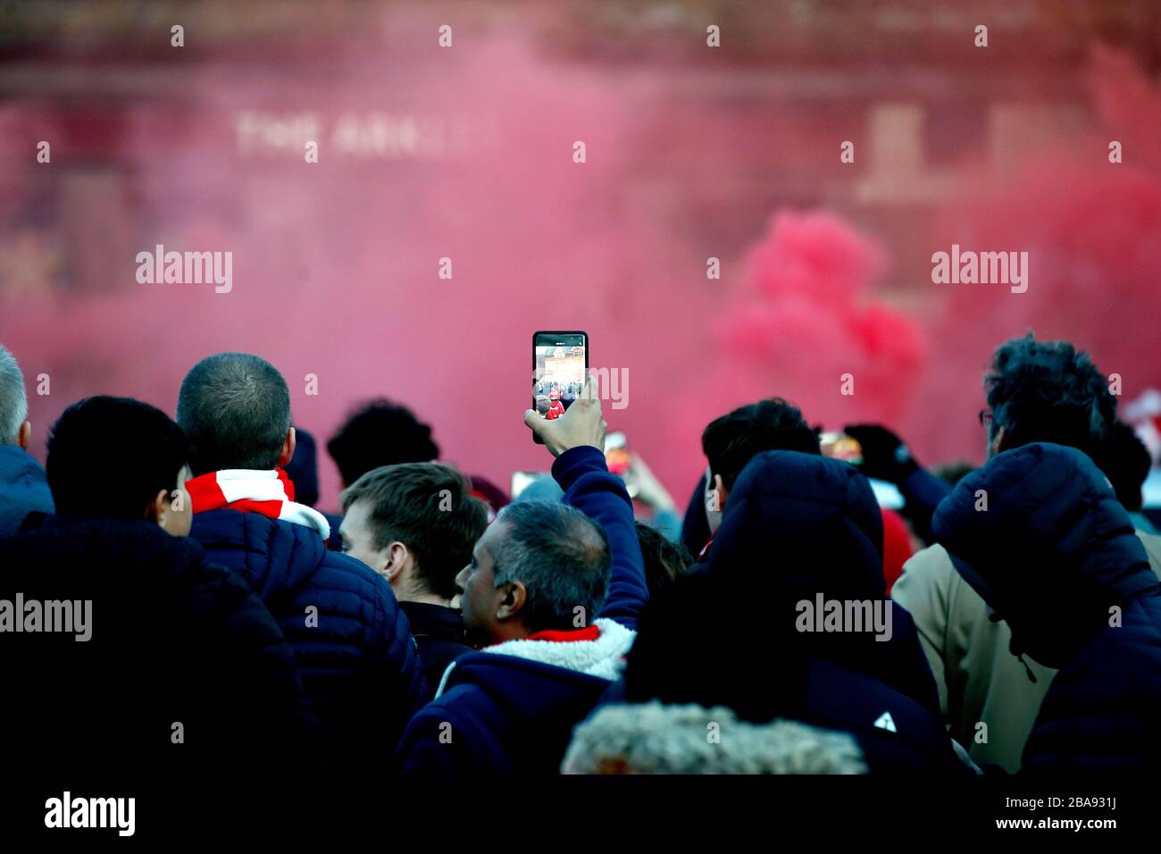 Les fans laissent floes devant le match lorsqu'un onlooker prend une vidéo sur leur téléphone Banque D'Images