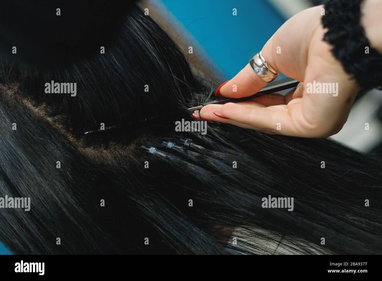 Femme professionnelle appliquant des extensions de cheveux avec différents types de poignées. Nano bagues extensions en véritables cheveux d'huma. Banque D'Images