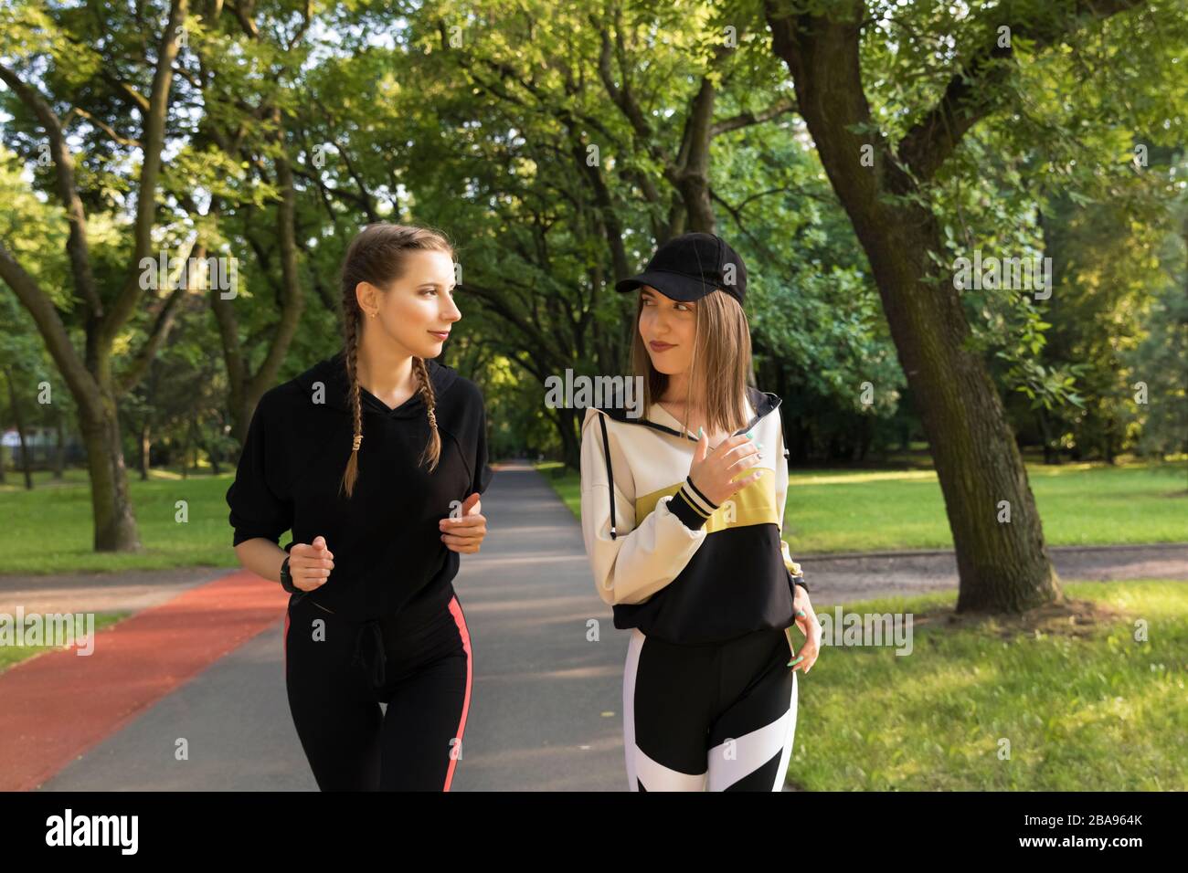 Les jeunes filles vont pour le sport dans la nature. La jeune génération mène un style de vie sain, les adolescents courent dans le parc le matin. Banque D'Images