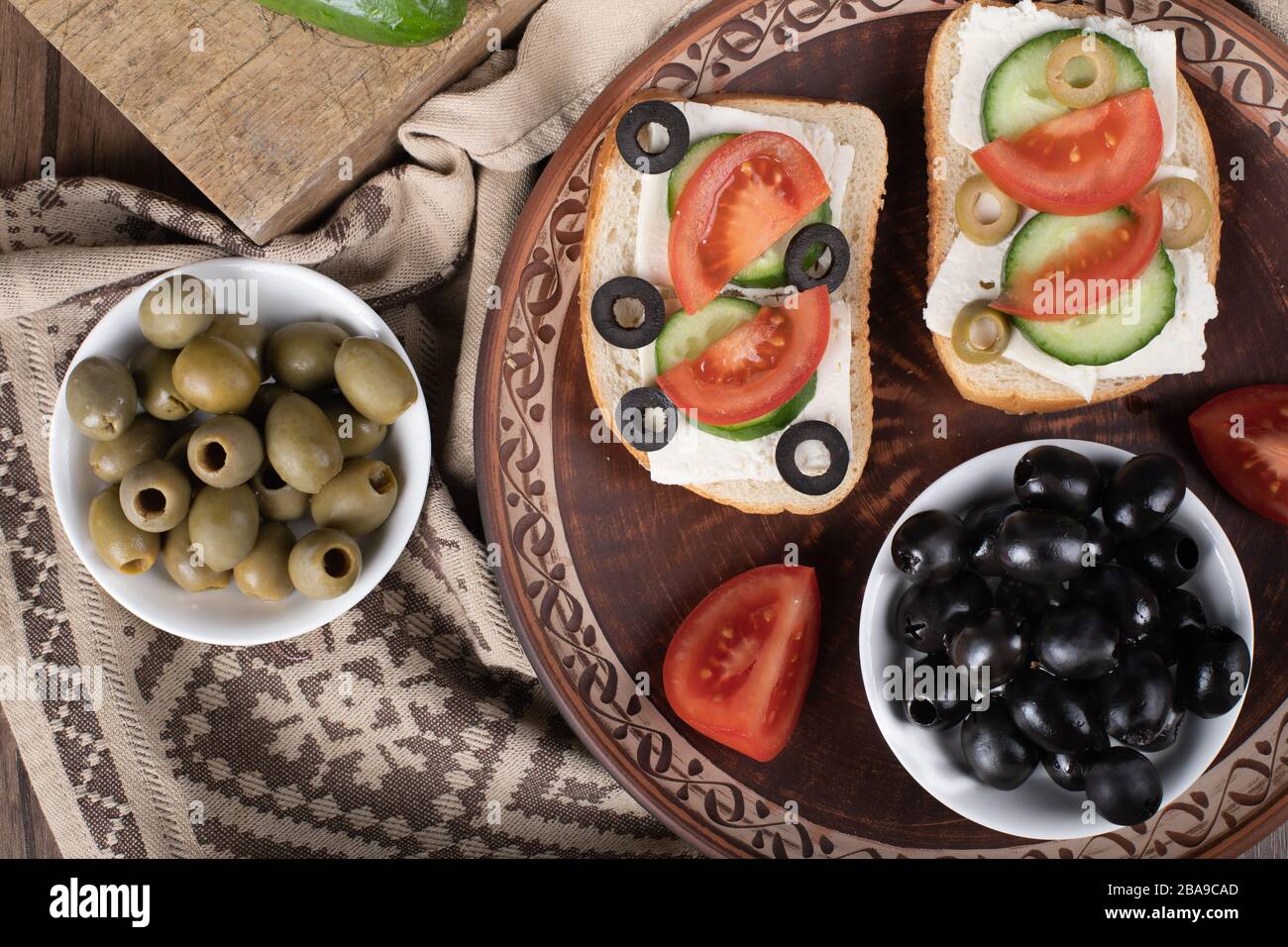 Olives noires marinées avec mini-sandwichs dans un plateau. Vue de dessus Banque D'Images