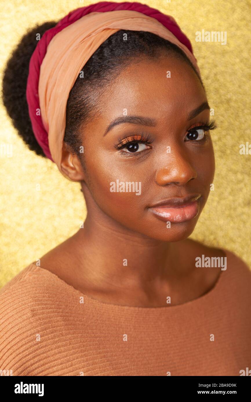 Portrait d'une jeune femme noire portant un bandeau et regardant l'appareil photo. Banque D'Images