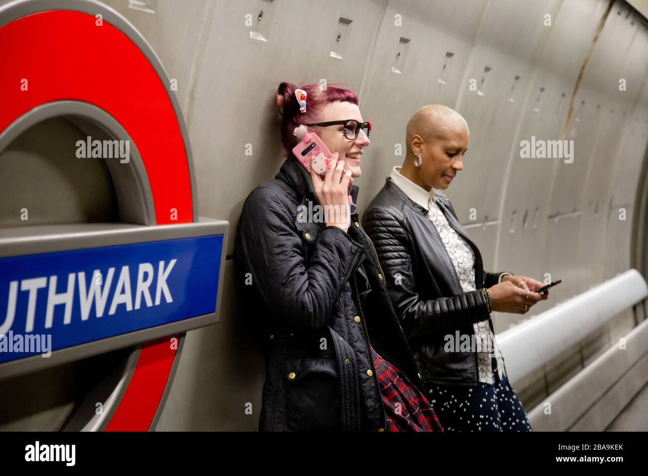 Un homme fait un appel téléphonique sur la plate-forme de la station de métro Southwark, qui fait partie du métro de Londres Banque D'Images
