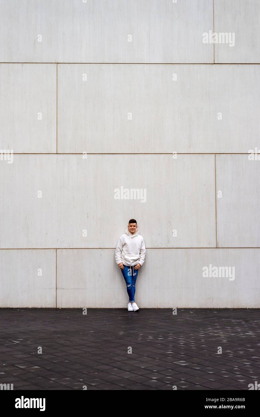 Portrait de jeune homme avec des mains sur la poche penchant sur le mur à l'extérieur Banque D'Images