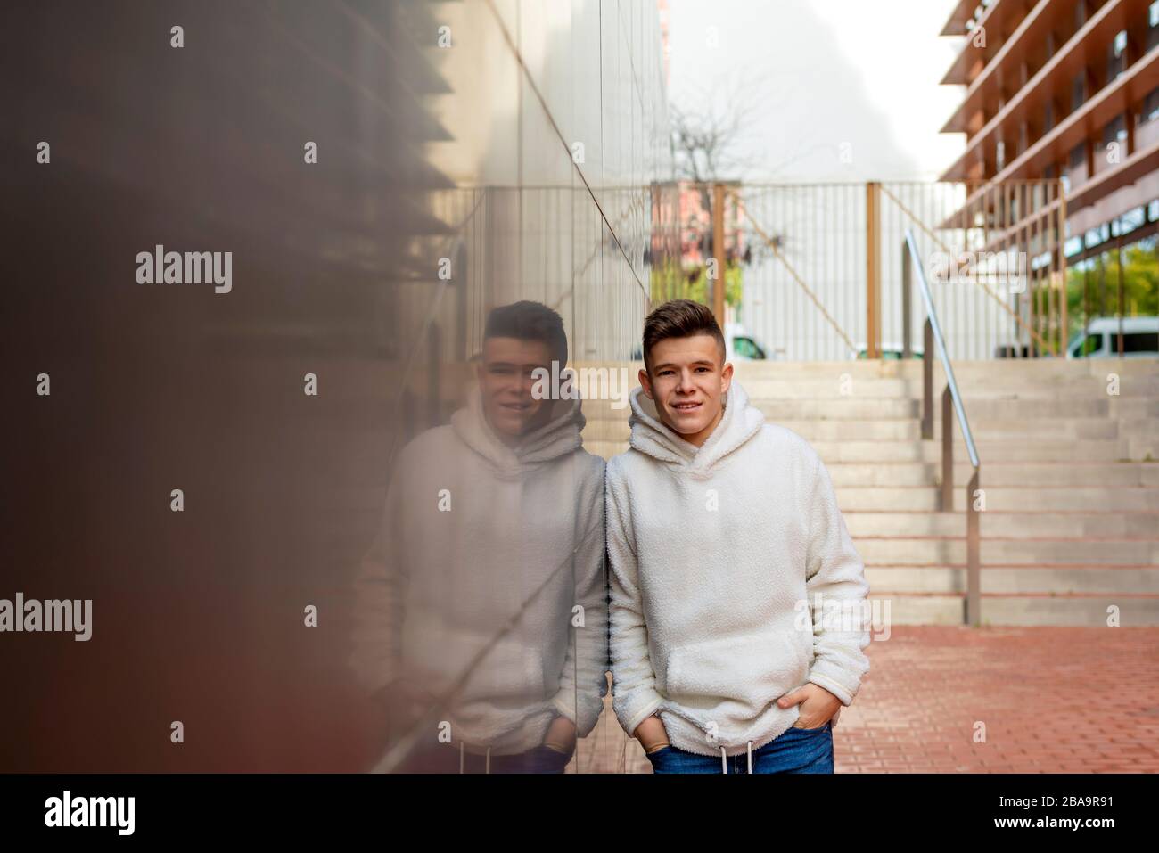 Portrait de jeune homme avec des mains sur la poche penchant sur le mur à l'extérieur Banque D'Images
