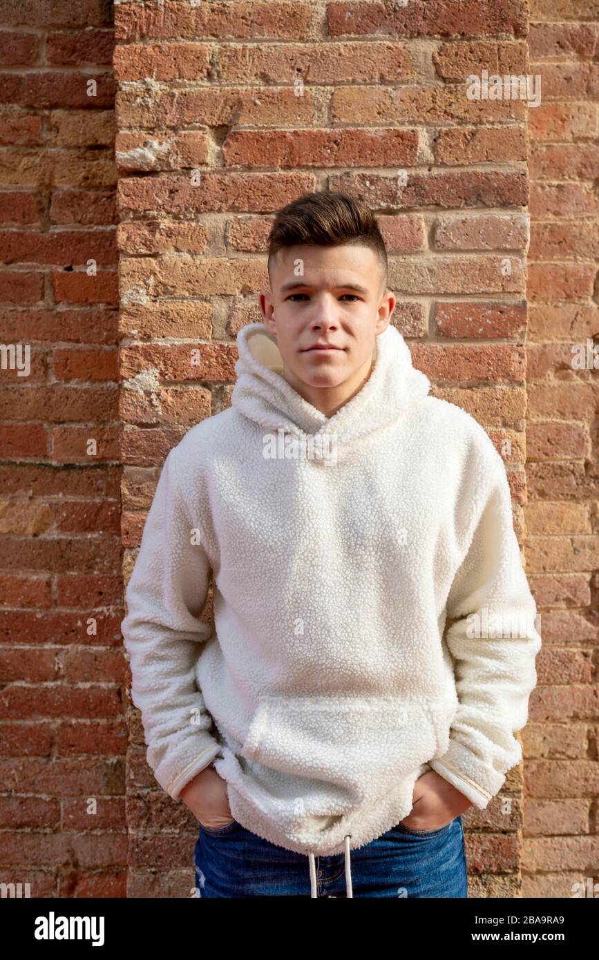 Portrait de jeune homme avec des mains sur la poche penchant sur le mur à l'extérieur Banque D'Images