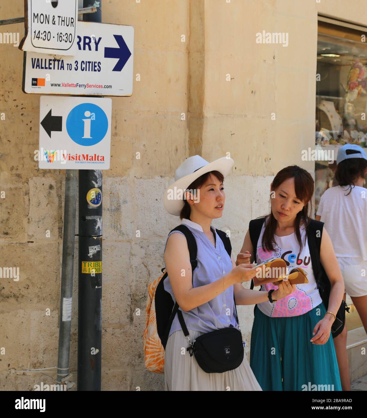 La Valette. Malte. Vieille ville. Deux touristes vérifiant le guide dans la rue. Banque D'Images