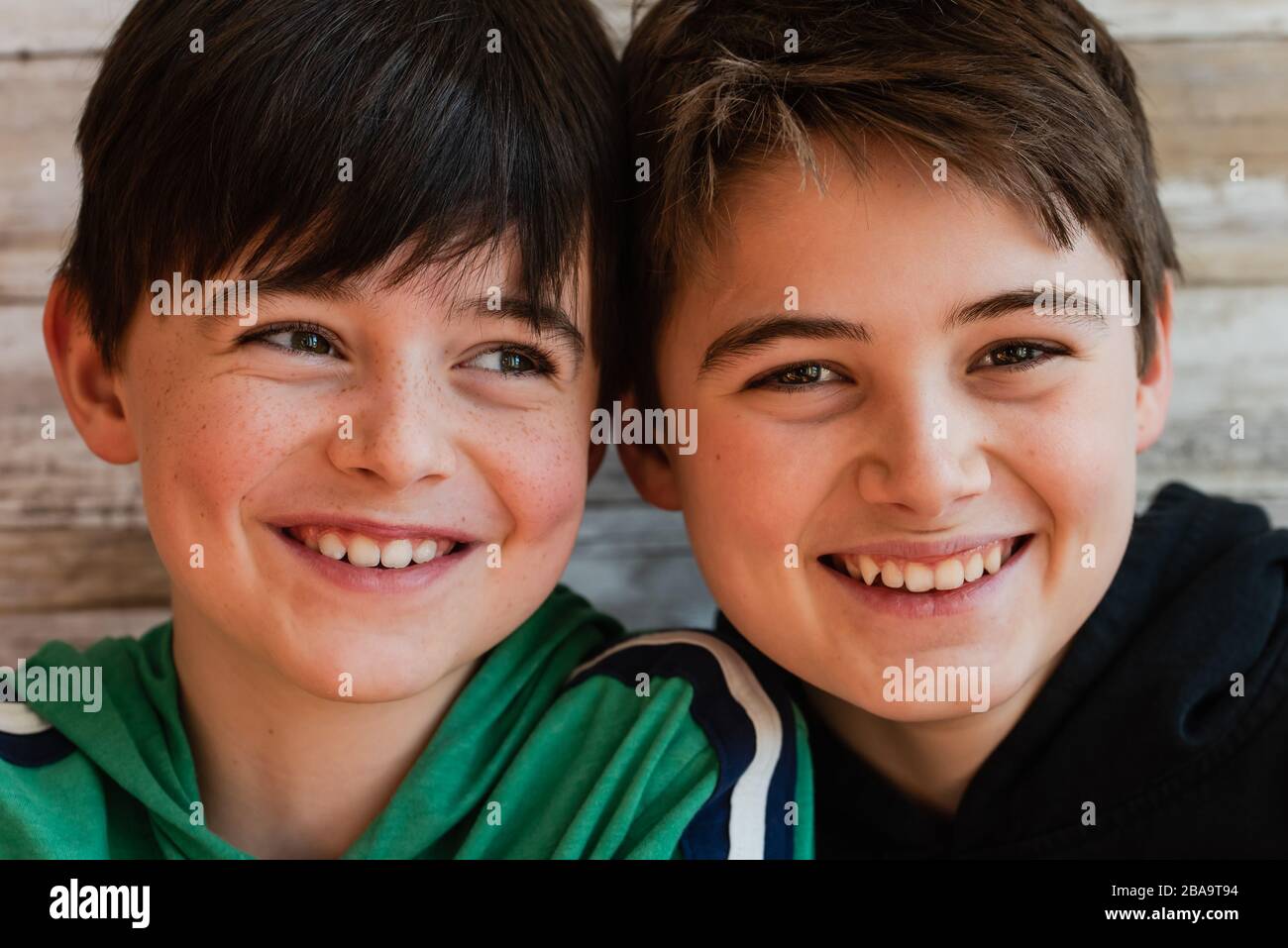Gros plan de deux garçons souriants, la tête étant proche les uns des autres. Banque D'Images