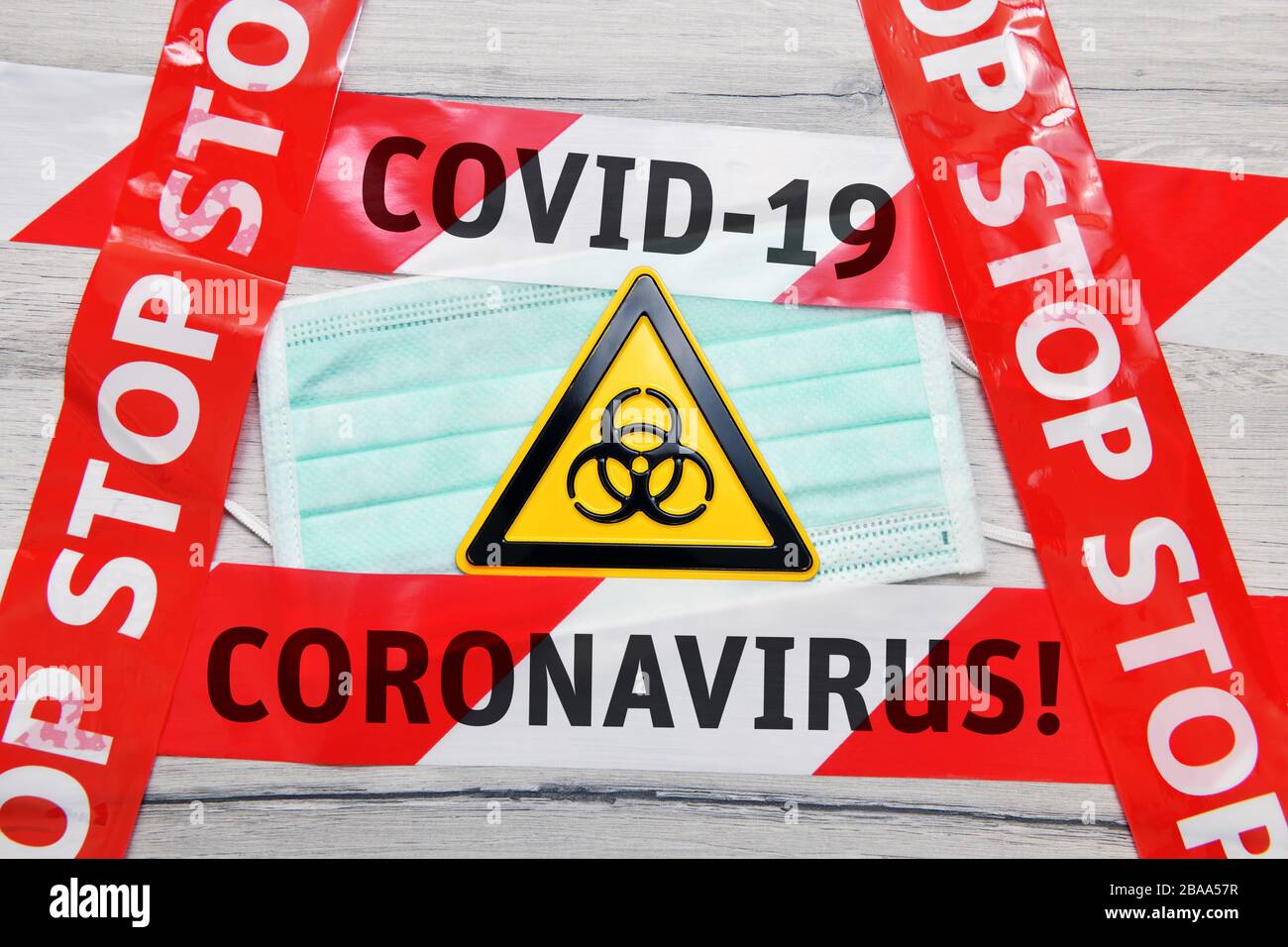 PHOTOMONTAGE, biologie danger signe sur le masque avec bande d'arrêt, photo symbolique Coronavirus, FOTOMONTAGE, Biogefährdungsschild auf Mundschutz mit Absperrband Banque D'Images