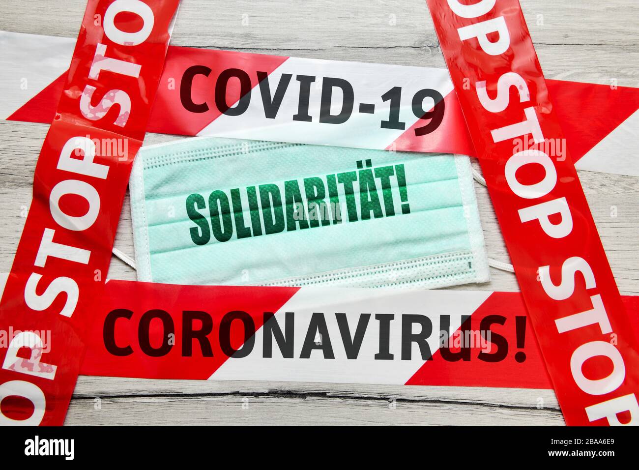 PHOTOMONTAGE, masque avec le trait de solidarité et d'arrêt ruban, la photo symbolique Coronavirus, FOTOMONTAGE, Mundschutz mit dem Schriftzug Solidarität und AB Banque D'Images