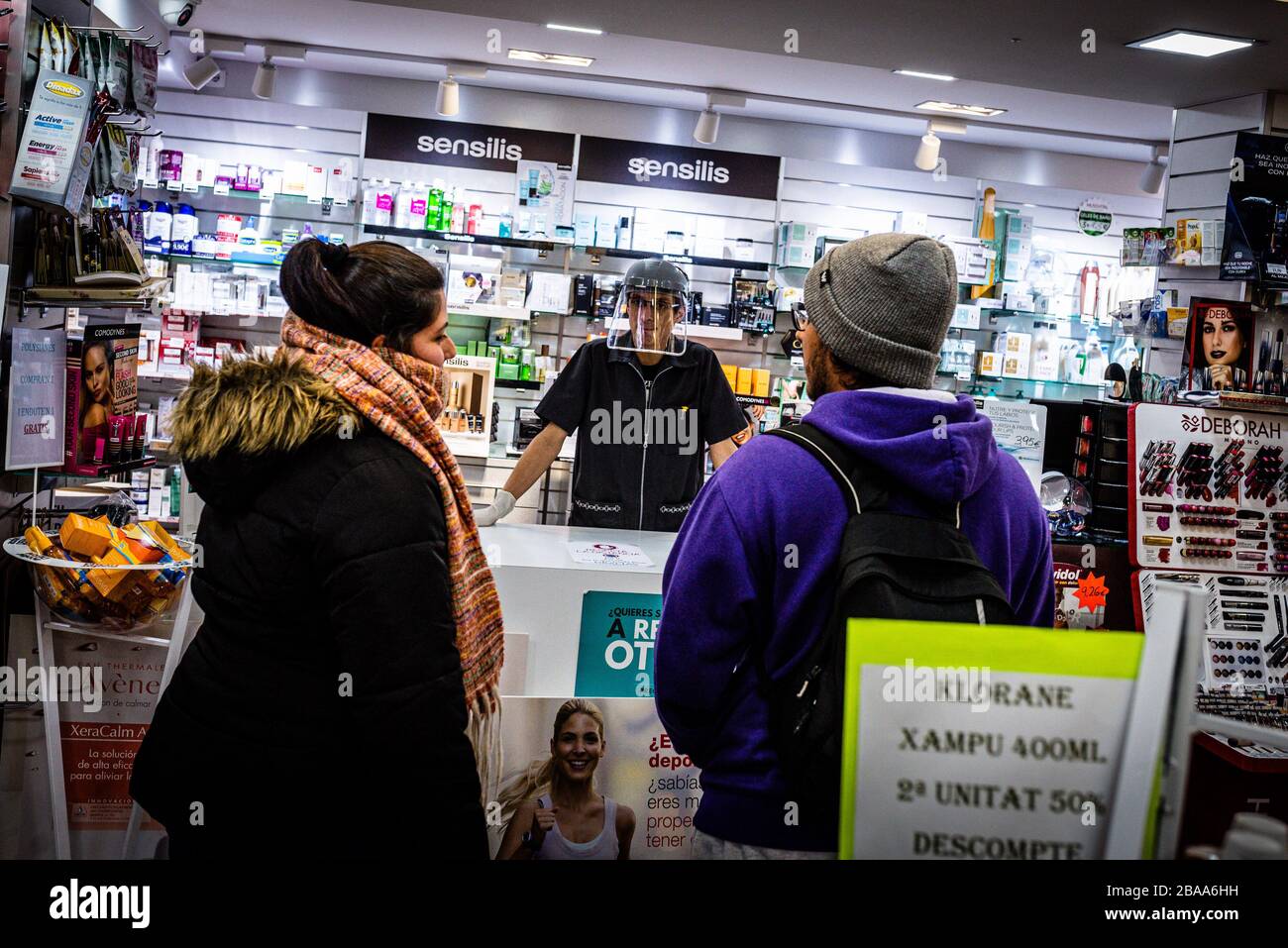 Barcelone, Espagne. 17 mars 2020. Un pharmacien portant un masque de protection énorme parle avec deux clients à Gérone, en Espagne. Le 17 mars 2020 . (Photo de Adrià Salido Zarco/INA photo Agency/Sipa USA) crédit: SIPA USA/Alay Live News Banque D'Images