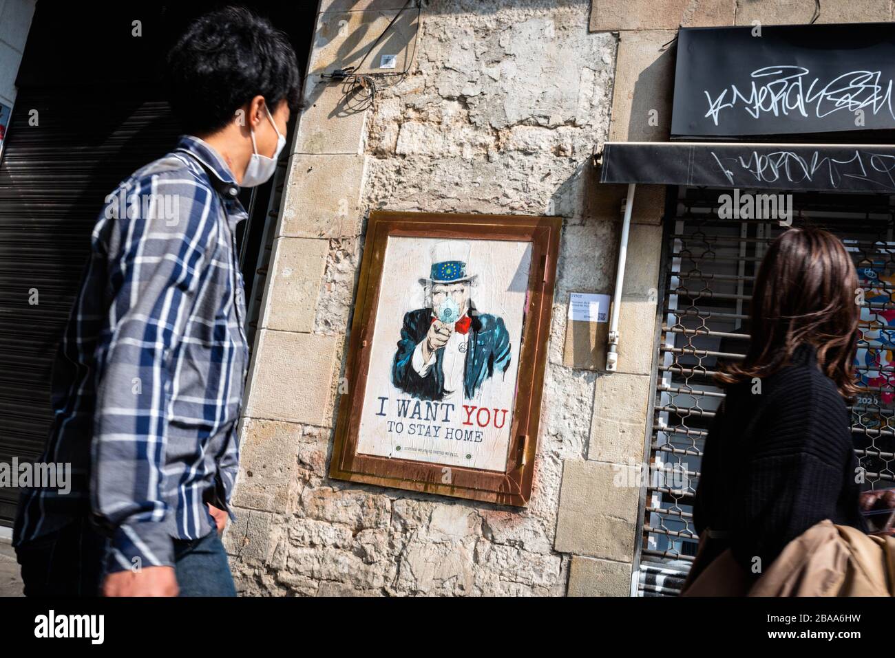 Barcelone, Espagne. 14 mars 2020. Un homme voit l'affiche de graffitis de l'artiste urbain TvBoy pour dire aux gens de rester chez eux. À Barcelone, ??Espagne, le 14 mars 2020. L'Espagne est l'un des pays les plus touchés par l'épidémie de Coronavirus (Covid-19). (Photo de Adrià Salido Zarco/INA photo Agency/Sipa USA) crédit: SIPA USA/Alay Live News Banque D'Images