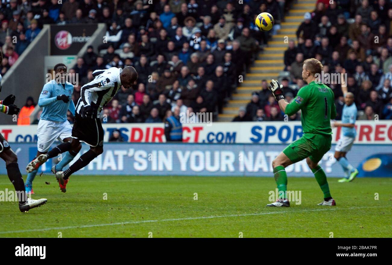 Demba Ba (à gauche) de Newcastle United obtient son premier but du jeu après le gardien de but de Manchester City Joe Hart (à droite) Banque D'Images