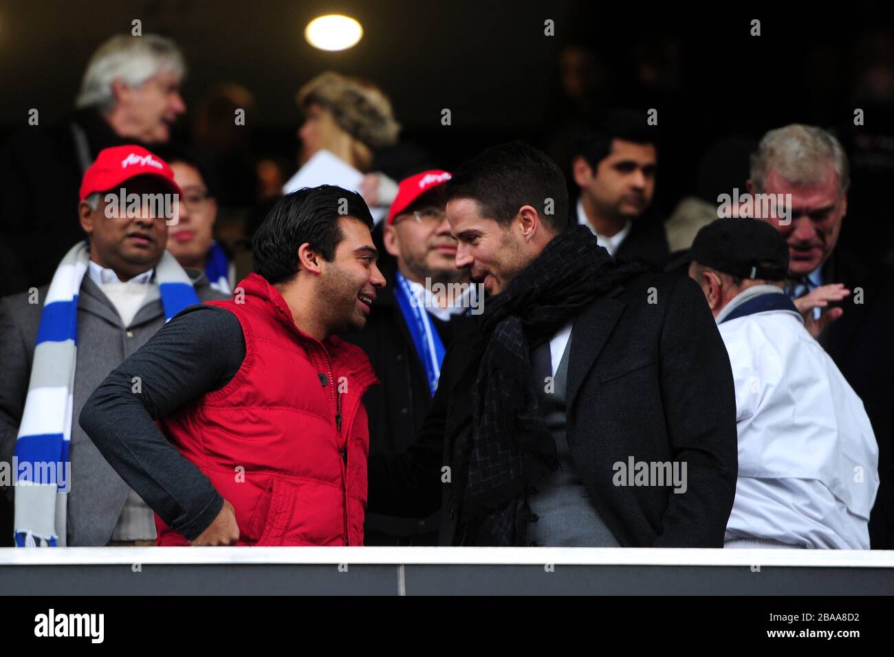 Le vice-président du QPR, Amit Bhatia (à gauche), discute avec Jamie Redknapp (à droite) dans les tribunes Banque D'Images