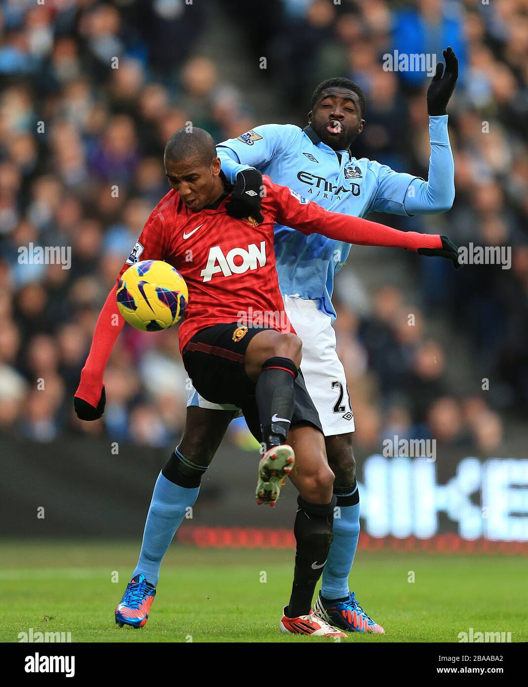 Kolo Toure de Manchester City (à droite) et Ashley Young (à gauche) de Manchester United affrontent le ballon Banque D'Images