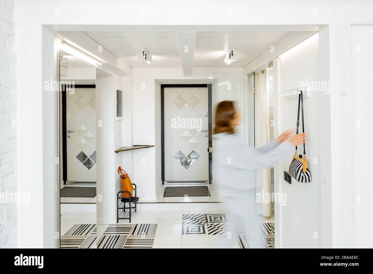 Vue intérieure du couloir lumineux et moderne de l'appartement avec une figurine humaine floue en mouvement Banque D'Images