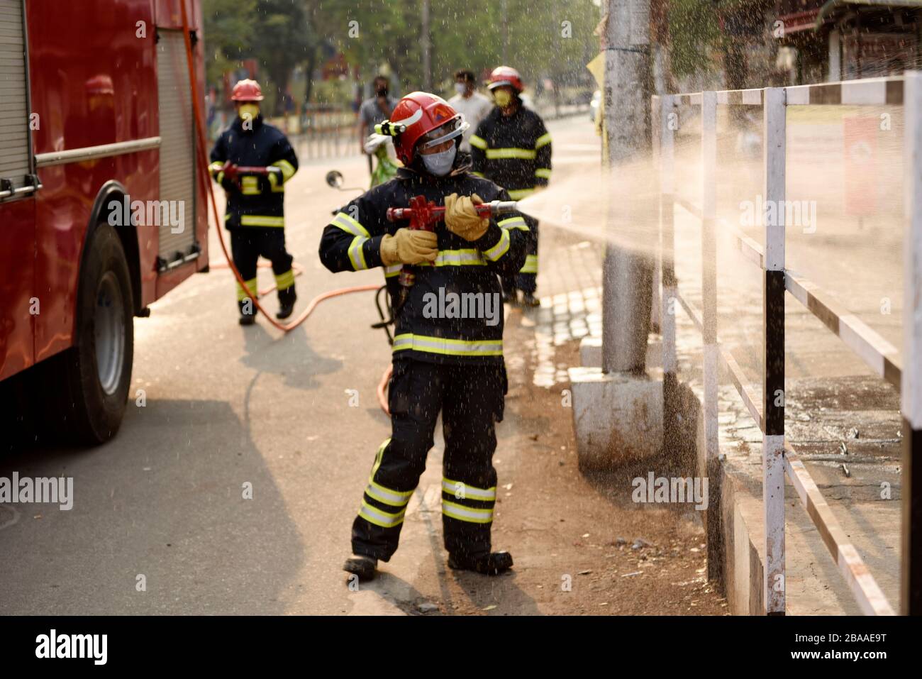 Guwahati, Assam, Inde. 26 mars 2020. Le pompier vaporise du désinfectant comme mesure préventive contre le coronavirus COVID-19 dans une rue d'un camion de pompiers à Guwahati. Crédit: David Talukdar/ZUMA Wire/Alay Live News Banque D'Images