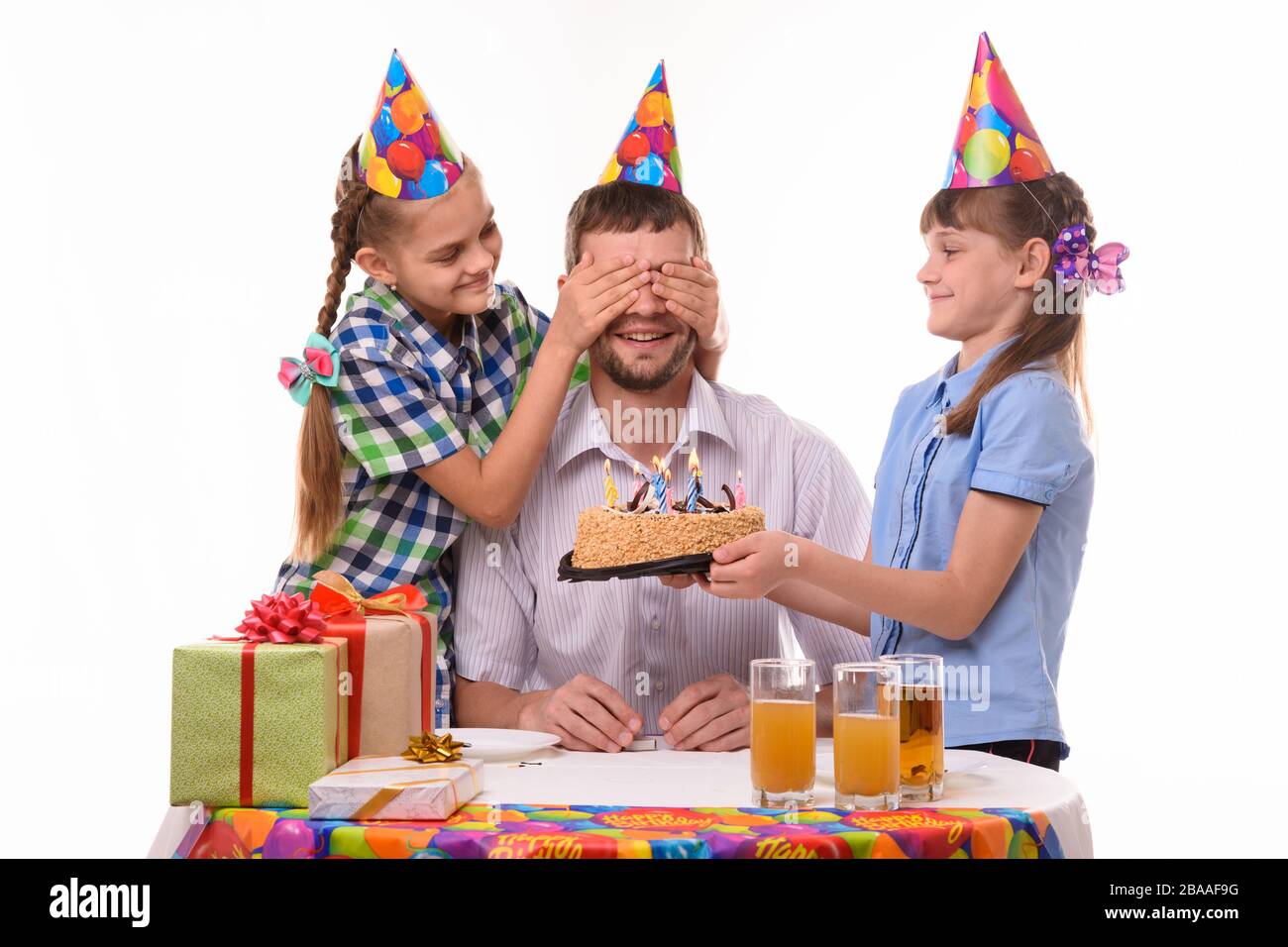 Les enfants donnent une douce surprise à leur père lors d'une fête d'anniversaire Banque D'Images