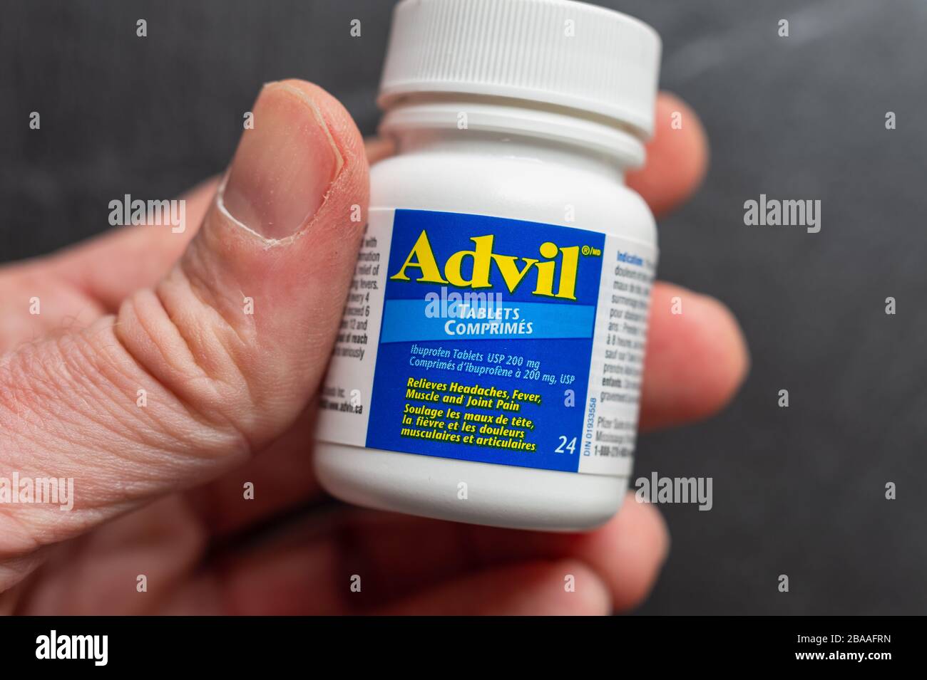 Montréal, CA 26 mars 2020: Main tenant une bouteille de comprimés d'Advil Ibuprofen. Banque D'Images