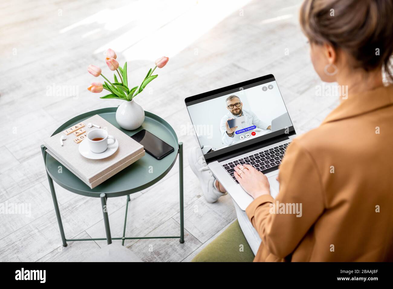 Femme d'affaires ayant une consultation en ligne avec un médecin en étant assis à la maison. Travail à domicile et concept de médecine pendant une quarantaine Banque D'Images
