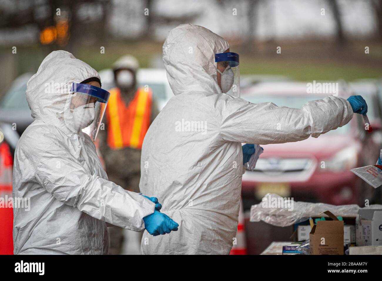 La Garde nationale de l'Air du New Jersey médite avec la 108ème Escadre traiter des spécimens à un site d'essais communautaires COVID-19 au Centre des arts de la Banque PNC le 23 mars 2020 à Holmdel, au New Jersey. Banque D'Images