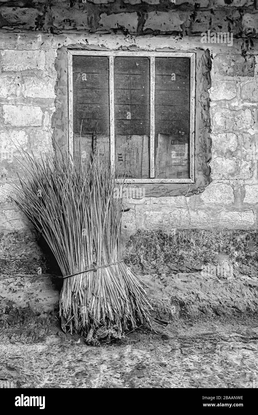 Prise de vue en niveaux de gris d'un tas de paille devant une maison rurale en pierre Banque D'Images Prise de vue en niveaux de gris d'un tas de paille devant une maison rurale en pierre Banque D'Images