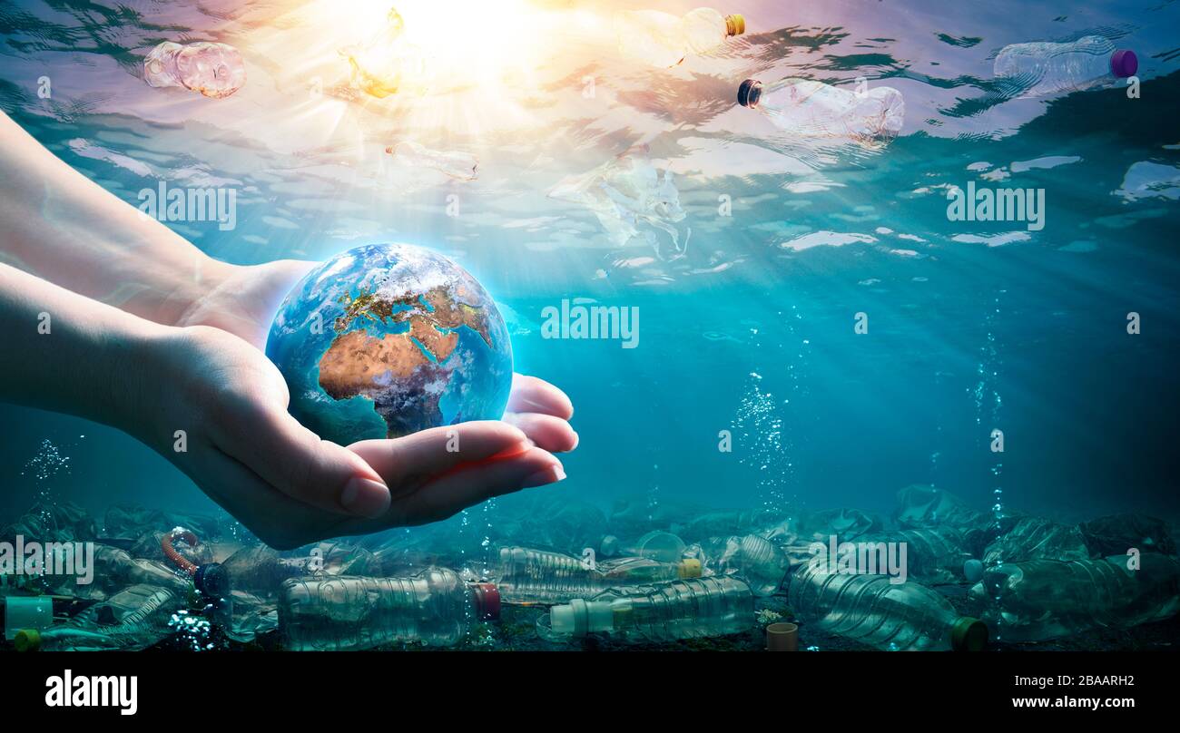 Déchets plastiques dans l'environnement - pollution des océans - mains tenant la Terre Banque D'Images