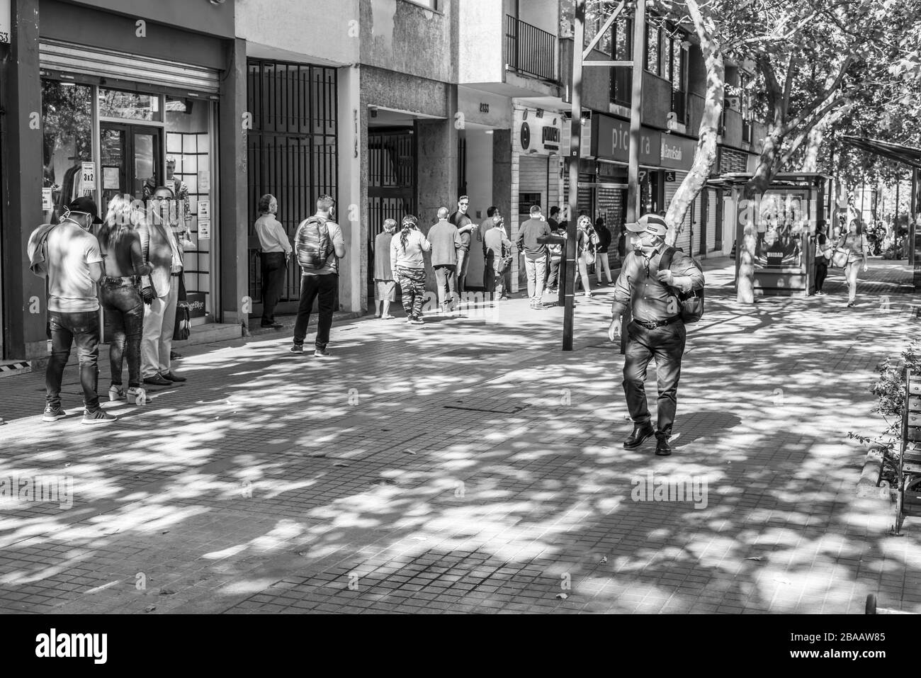 Les gens qui attendent dans les rues de Providencia pour entrer dans les banques et les magasins au cours des dernières heures avant le couvre-feu parce que la maladie de coronavirus COVID-19 Banque D'Images