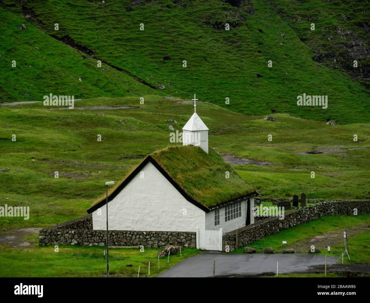 Îles Féroé, Streymoy, Saksun. Vue sur l'église et la vallée de Saksun. Bâtiment blanc avec toit en herbe debout hors des champs verts. Banque D'Images