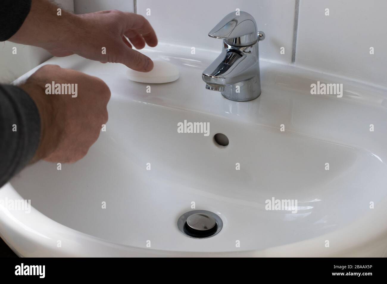 Détail d'un jeune homme se lavant les mains avec du savon sous l'eau courante afin de réduire le risque d'infection pendant la pandémie du virus corona Banque D'Images