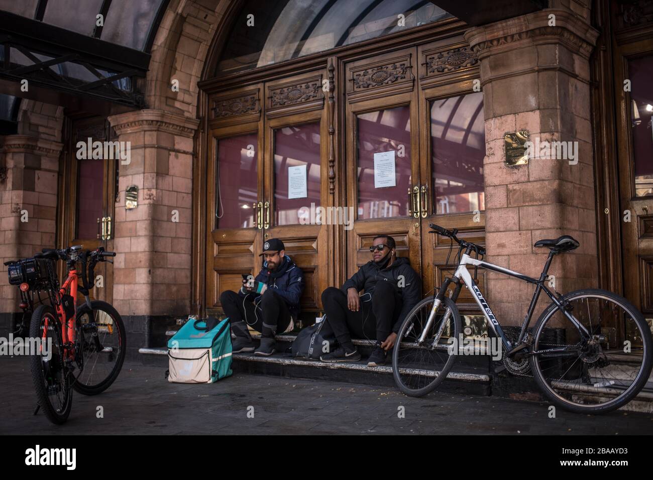 Londres, Royaume-Uni. 26 mars 2020. Les cyclistes se reposent devant le Palace Theatre à partir de trois jours après que le Premier ministre Johnson a demandé à ses compatriotes de laisser leurs propres quatre murs aussi peu que possible. Crédit: Oliver Weiken/dpa/Alay Live News Banque D'Images