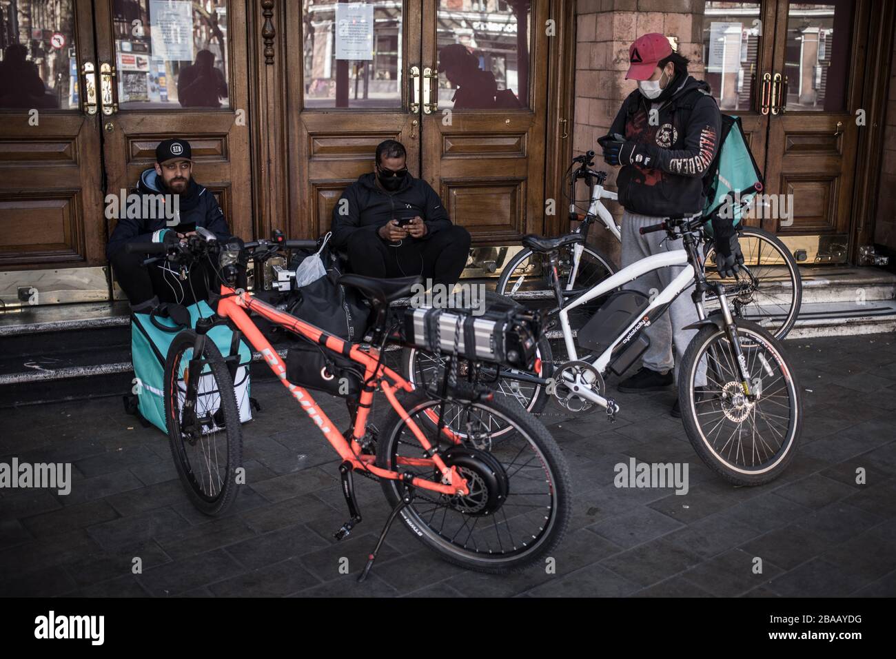 Londres, Royaume-Uni. 26 mars 2020. Les cyclistes se reposent devant le Palace Theatre à partir de trois jours après que le Premier ministre Johnson a demandé à ses compatriotes de laisser leurs propres quatre murs aussi peu que possible. Crédit: Oliver Weiken/dpa/Alay Live News Banque D'Images