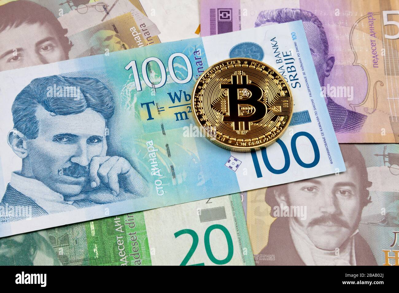 Gros plan sur une pièce de monnaie en Bitcoin doré au-dessus d'une pile de billets dinars serbes. Banque D'Images