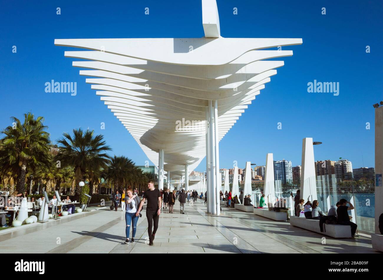 Malaga, Espagne : les locaux et les touristes marchent sous les parasols modernes de la promenade aux quais du port. Banque D'Images