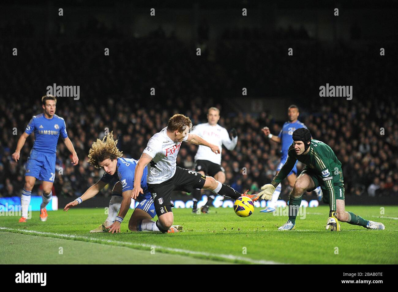 John Arne Riise de Fulham (au centre) et David Luiz de Chelsea (à gauche) se battent pour le ballon alors que Petr Cech, gardien de but de Chelsea (à droite) regarde Banque D'Images