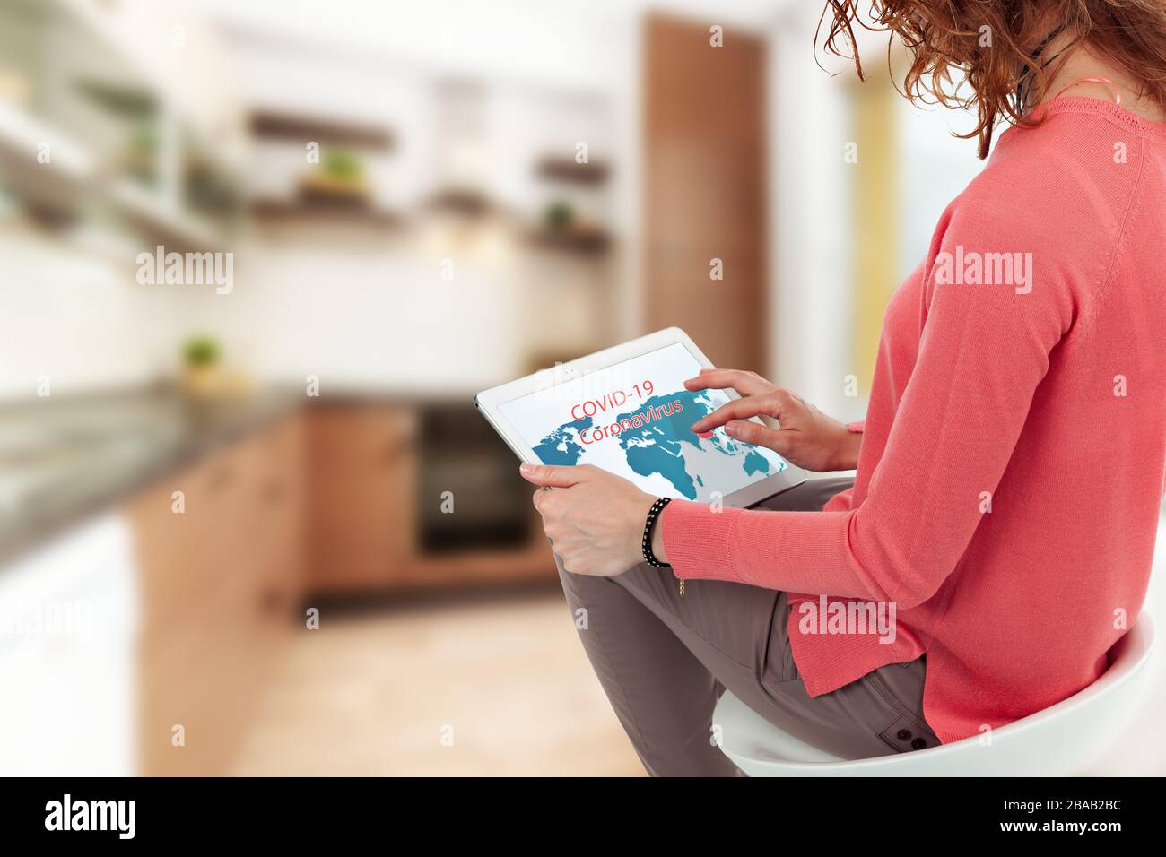 Une femme regarde dans un comprimé et regarde des informations pour le coronavirus. Banque D'Images