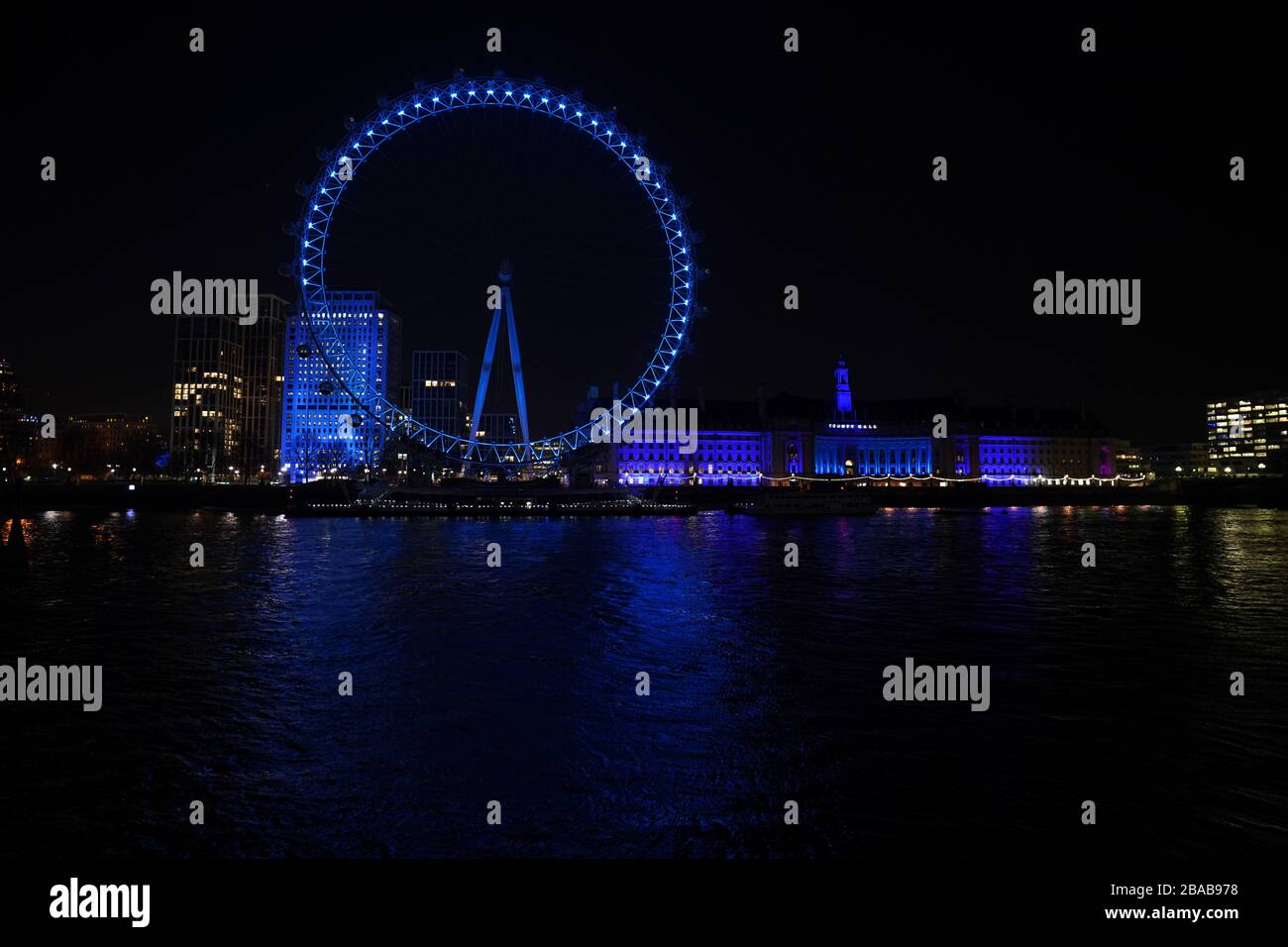 Le London Eye and County Hall de Londres est éclairé en bleu par un geste de grâce au personnel du NHS qui tente de lutter contre le coronavirus. Un hommage national pour les héros de la santé de première ligne a lieu dans tout le Royaume-Uni avec un grand nombre d'applaudissements sur les portes, les fenêtres et les balcons jeudi à 20:00. Banque D'Images