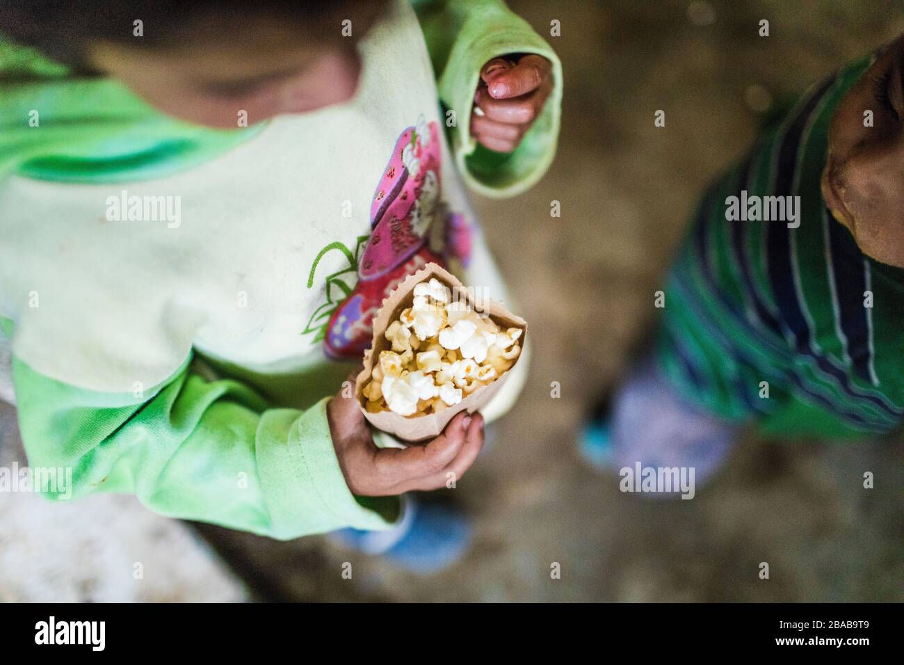 Vue en grand angle des enfants qui mangent du pop-corn dans un sac en papier. Banque D'Images