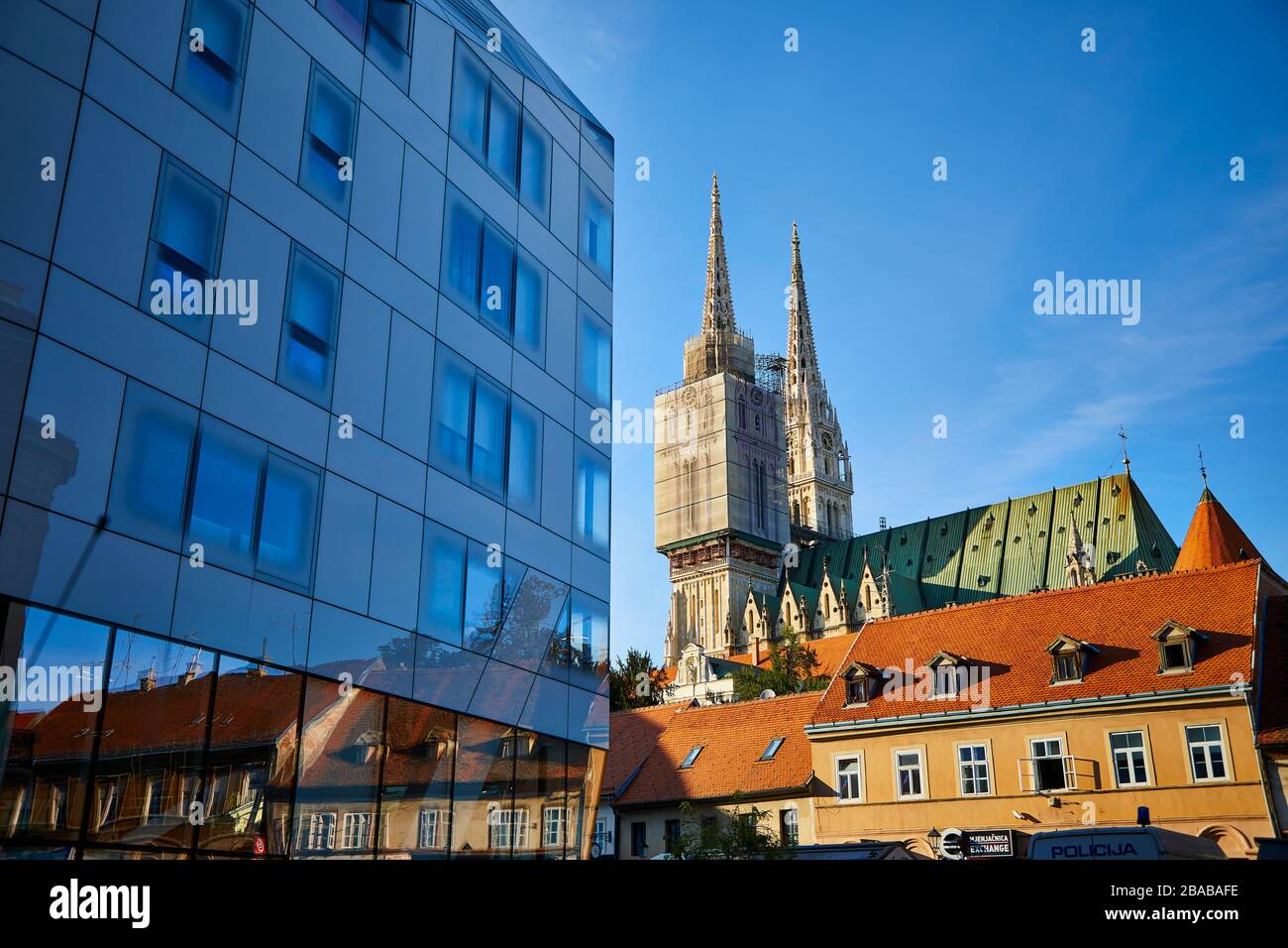 En fin d'après-midi, le soleil frappe la cathédrale de Zagreb avec le bâtiment moderne de bureaux gouvernementaux en premier plan. Banque D'Images