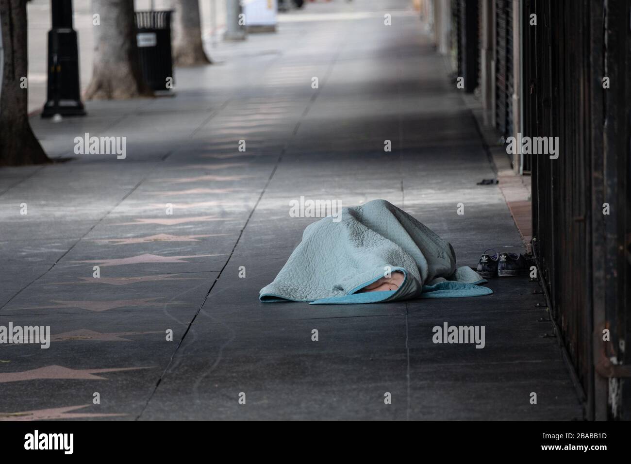 Un sans-abri dormant sur le trottoir vide à côté de Hollywood Stars le 25 mars 2020 à Hollywood, Californie quelques jours après Los Angeles County ann Banque D'Images