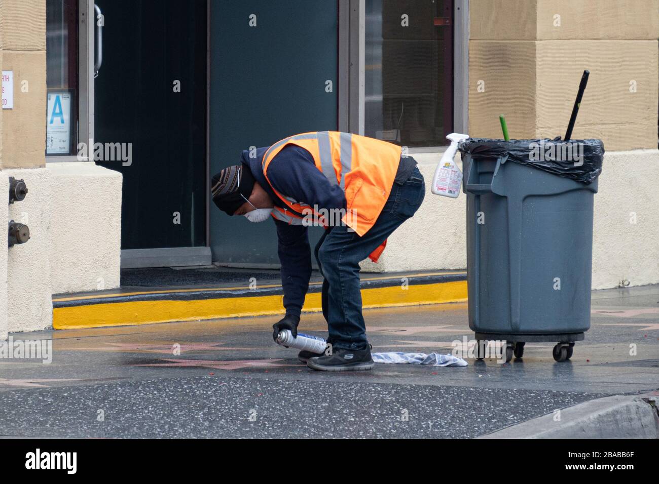 Un nettoyeur de rue portant un masque de protection utilise un nettoyant vaporisateur pour nettoyer l'étoile sur le Hollywood Walk of Fame, Hollywood, CA, le 25 mars Banque D'Images